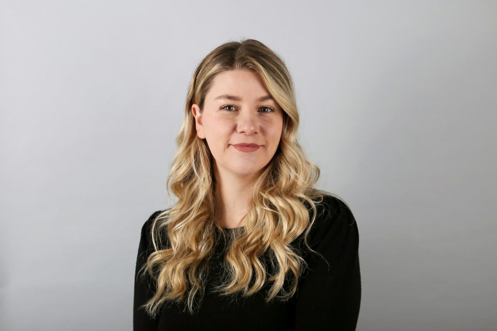 a woman with long blonde hair wearing a black shirt