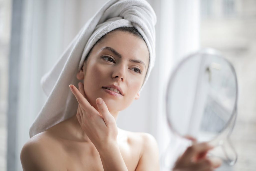 A serene and elegant woman enjoys a skincare ritual, enhancing her natural beauty in the comfort of her home.