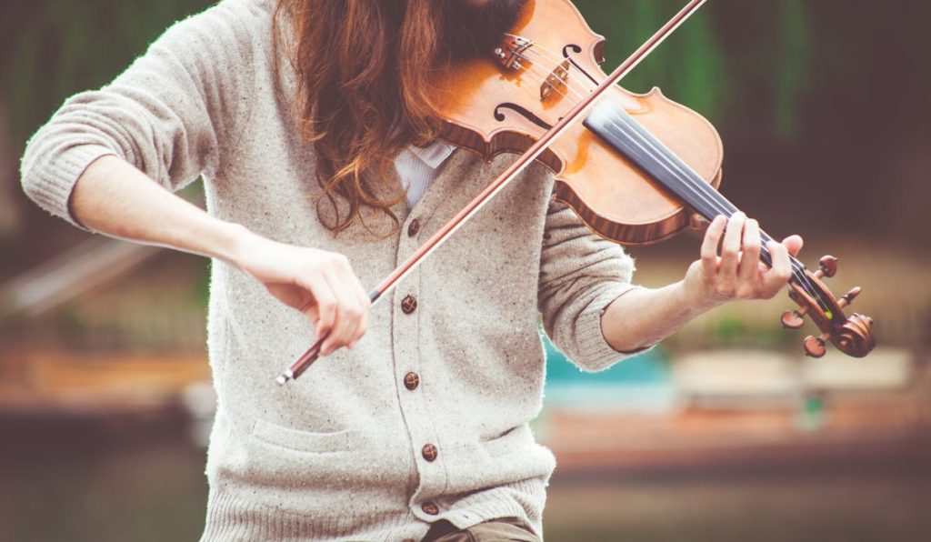 Close-up of a violinist playing outdoors in warm tones, capturing the essence of live music.