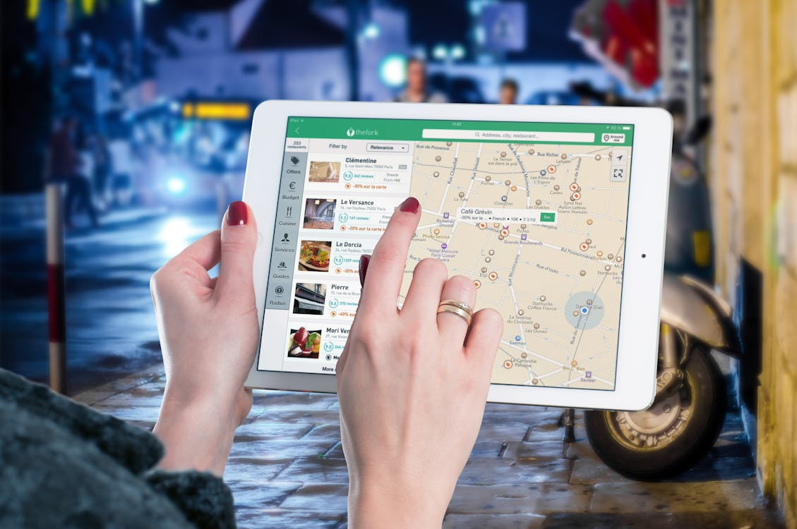 Free Hands using a digital map on a tablet in an urban setting at night, illustrating navigation and technology. Stock Photo